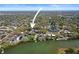 Aerial view showing the waterfront location of the beautiful pink home in a lush landscape at 1874 N Washington Ave, Clearwater, FL 33755