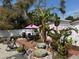 Relaxing backyard with an outdoor kitchen, rock water feature, landscaping and pink umbrella at 1874 N Washington Ave, Clearwater, FL 33755