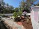 Wonderful backyard with an outdoor table and chairs set for entertaining with a pink umbrella at 1874 N Washington Ave, Clearwater, FL 33755