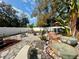 Secluded backyard with a fire pit, outdoor seating, and lush landscaping at 1874 N Washington Ave, Clearwater, FL 33755