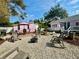 Spacious backyard with a firepit, chairs, outdoor shed, and a view of the charming pink house at 1874 N Washington Ave, Clearwater, FL 33755