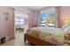 Inviting pink bedroom with large windows, leading into a bright sunroom with wicker furniture at 1874 N Washington Ave, Clearwater, FL 33755
