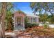 Charming pink cottage with a brick walkway, white picket fence, and well-maintained landscaping at 1874 N Washington Ave, Clearwater, FL 33755