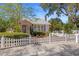 View of the exterior of the home, displaying a white picket fence and tropical landscaping at 1874 N Washington Ave, Clearwater, FL 33755