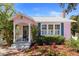 Beautiful pink home with a covered front porch and lush landscaping at 1874 N Washington Ave, Clearwater, FL 33755