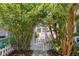 Charming home entrance featuring a white picket fence and gate with lush greenery at 1874 N Washington Ave, Clearwater, FL 33755