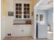 Hallway showing a built in cabinet and access to a room with a laundry machine at 1874 N Washington Ave, Clearwater, FL 33755