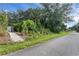 A view of the property with lush landscaping along a road at 1874 N Washington Ave, Clearwater, FL 33755