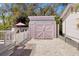 Exterior shot of a matching pink shed on a gravel drive, creating an added storage space at 1874 N Washington Ave, Clearwater, FL 33755