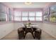 Bright sunroom featuring a glass table, window views, and cozy seating, perfect for relaxing at 1874 N Washington Ave, Clearwater, FL 33755