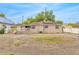 Rear exterior featuring a small porch of single-story home with large gravel backyard at 1909 N Macdill Ave, Tampa, FL 33607