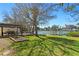 Large backyard with a covered patio, outdoor dining, lush grass, and waterfront views, ideal for outdoor living at 222 Mar St, St Pete Beach, FL 33706