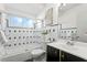 Stylish bathroom with a shower-tub combo, black vanity, and patterned tile at 222 Mar St, St Pete Beach, FL 33706