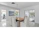 Bright dining room with wood table, chandelier, and access to the lanai at 222 Mar St, St Pete Beach, FL 33706