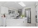 Modern white kitchen with stainless steel appliances and breakfast bar seating at 222 Mar St, St Pete Beach, FL 33706