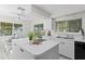 White kitchen with island, modern appliances, and views of the canal from the breakfast nook at 222 Mar St, St Pete Beach, FL 33706