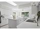 Bright kitchen with white cabinetry, island, and views of the backyard and waterway at 222 Mar St, St Pete Beach, FL 33706