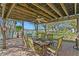 Covered outdoor dining area featuring a round table with seating for six, set on a brick patio with water views at 222 Mar St, St Pete Beach, FL 33706