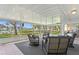 Inviting patio area with black wicker chairs and a grey rug, offering views of the waterfront and lush landscaping at 222 Mar St, St Pete Beach, FL 33706