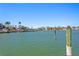 Scenic waterfront view featuring calm green waters, waterfront homes, docks, and palm trees under a clear blue sky at 222 Mar St, St Pete Beach, FL 33706