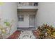 Front entry with small garden of plants, white stones and stepping stones, plus a view of a second story balcony at 2625 State Road 590 # 2612, Clearwater, FL 33759