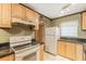 Classic kitchen with wooden cabinets, stainless steel appliances, laminate countertops, and white tiled flooring at 2625 State Road 590 # 2612, Clearwater, FL 33759