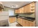 Classic kitchen with wooden cabinets, stainless steel appliances, laminate countertops, and white tiled flooring at 2625 State Road 590 # 2612, Clearwater, FL 33759
