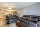 Spacious living room area featuring leather couches, a ceiling fan, and partial views into the nearby kitchen area at 2625 State Road 590 # 2612, Clearwater, FL 33759