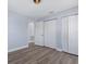 Bedroom featuring wood-look flooring, closet, white trim, and access door at 2901 W Nassau St, Tampa, FL 33607