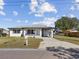 Charming home with a covered carport, well-manicured lawn, and beautifully painted in white at 2901 W Nassau St, Tampa, FL 33607