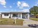 Charming home with a covered carport, well-manicured lawn, and beautifully painted in white at 2901 W Nassau St, Tampa, FL 33607