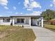 Charming home with a covered carport, well-manicured lawn, and beautifully painted in white at 2901 W Nassau St, Tampa, FL 33607