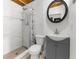 Clean bathroom with white-tiled walk-in shower, vanity, and a modern round mirror at 3609 Flamingo Blvd, Hernando Beach, FL 34607