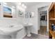 Bright bathroom with double sinks, decorative mirrors, and a walk-in closet view at 3609 Flamingo Blvd, Hernando Beach, FL 34607