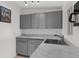 Kitchen area featuring granite counters, stainless steel faucet, and gray cabinets at 3609 Flamingo Blvd, Hernando Beach, FL 34607
