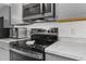 Modern kitchen featuring updated appliances, granite counters, and stylish gray cabinets at 3609 Flamingo Blvd, Hernando Beach, FL 34607