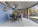 Comfortable covered patio with ceiling fans, featuring a dining set perfect for outdoor gatherings at 3609 Flamingo Blvd, Hernando Beach, FL 34607