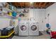 Basement laundry area with washer, dryer, water heater, and extra storage space at 4750 Foothill Dr, Holiday, FL 34690