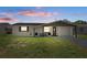 Charming single-story home with solar panels, white brick, and dark trim at dusk at 4750 Foothill Dr, Holiday, FL 34690