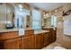 Well-lit bathroom featuring dual vanities, granite countertops, and travertine tile at 479 E Shore Dr # 8, Clearwater, FL 33767