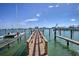A wooden dock extends into the water, with boats moored nearby and a view of buildings across the water at 479 E Shore Dr # 8, Clearwater, FL 33767