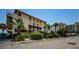 The exterior of a multi-story condo building with a parking lot and tropical landscaping at 479 E Shore Dr # 8, Clearwater, FL 33767