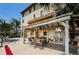 Exterior shot of the outdoor patio, offering an idyllic setting with seating, a ceiling fan, and lush, tropical landscaping at 479 E Shore Dr # 8, Clearwater, FL 33767