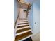 Well-maintained staircase with hardwood steps, a white railing, and natural light at 479 E Shore Dr # 8, Clearwater, FL 33767