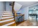 Elegant staircase featuring wood steps and a wrought iron railing detail with views to the living area at 479 E Shore Dr # 8, Clearwater, FL 33767