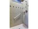 Bathroom shower with tiled walls and a safety grab bar for accessibility at 501 Pinewood Dr, Oldsmar, FL 34677