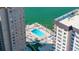Beautiful aerial view of outdoor pool and tiki seating area with waterfront access, set between condominium buildings at 5220 Brittany S Dr # 309, St Petersburg, FL 33715