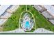 Aerial view of a community pool with a lush green lawn and plenty of lounge chairs at 5220 Brittany S Dr # 309, St Petersburg, FL 33715