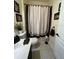 Cozy bathroom features a shower with a stylish dark-bordered curtain, complementing the neutral tile flooring at 5229 Clover Mist Dr, Apollo Beach, FL 33572