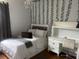 Cozy bedroom featuring a bed, white desk, hardwood floors, and lovely decorative vines at 5229 Clover Mist Dr, Apollo Beach, FL 33572